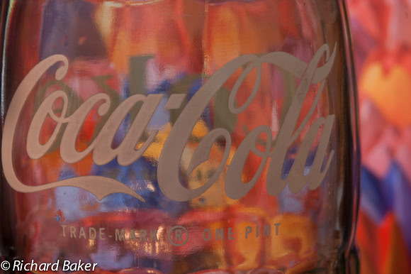 Coca-Cola bottle with tulips behind.